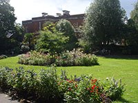 A flower garden and lawn in a park in Exeter